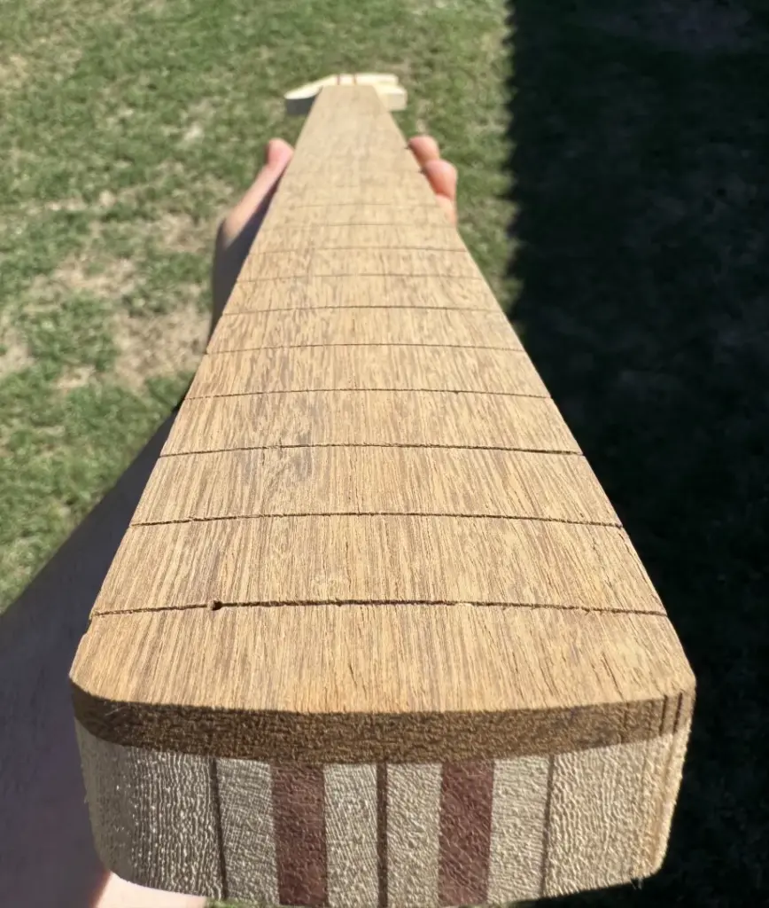 Vista frontale della tastiera raggiata in iroko con side dot bianco sul bordo del manico
